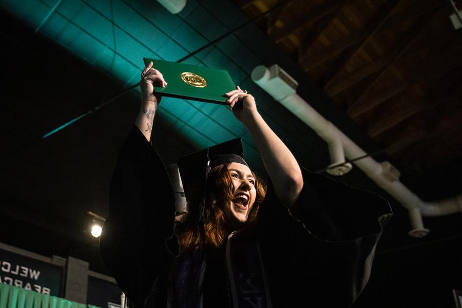 周六，<a href='http://museum.lscarpet.net'>和记棋牌娱乐</a>的一名毕业生在毕业典礼上展示她的毕业证书.